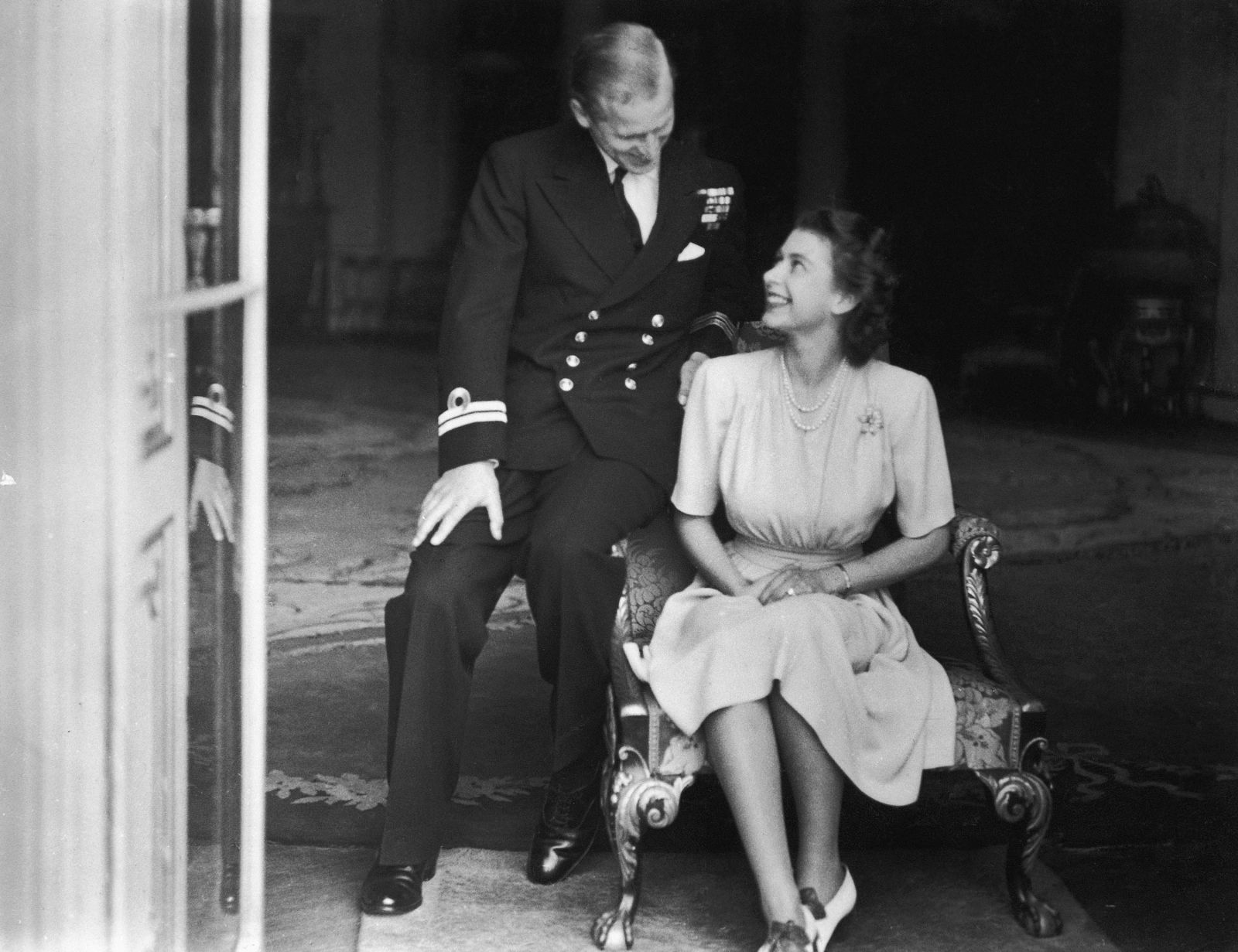 Prince Philip sits with his fiancee, Princess Elizabeth, in July 1947. He had become a naturalized British citizen and a commoner, using the surname Mountbatten, an English translation of his mother's maiden name. He was also an officer of the British Royal Navy and fought in World War II.Topical Press Agency/Hulton Royals Collection/Getty Images