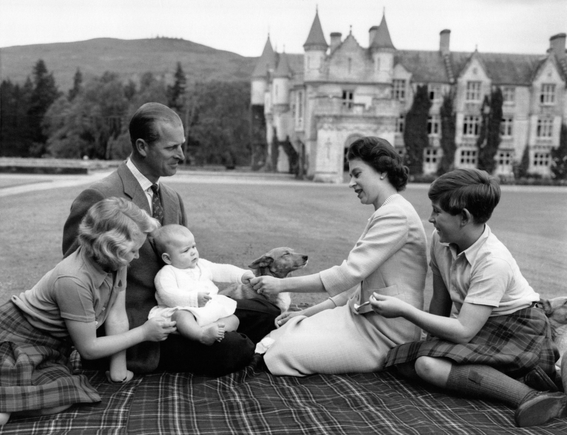 In 1960, relaxing in the grounds of Balmoral with a baby Prince Andrew. © Getty Images