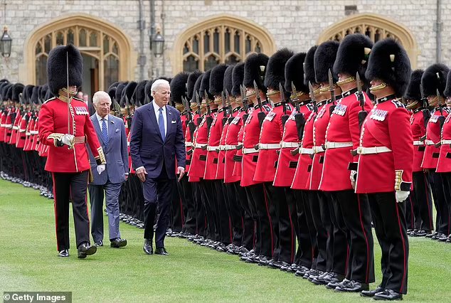 President Biden walks in front of the King as they inspect the Welsh Guards at Windsor Castle