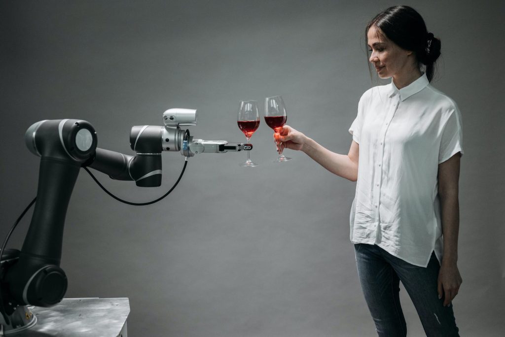 Robotic arm, wine glass, and female.